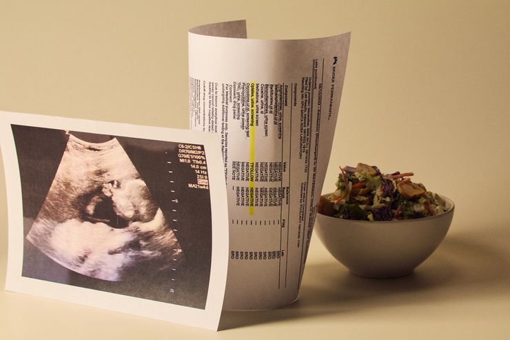 Three items are arranged on a white surface: a salad in a white bowl, a copy of a sonogram, and a printout of a false positive drug test result.